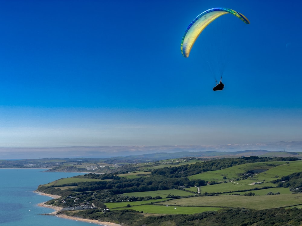 a paraglider is flying over a large body of water