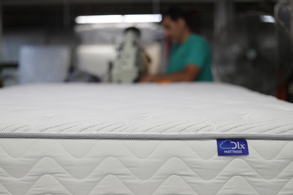 a man is working on a mattress in a warehouse