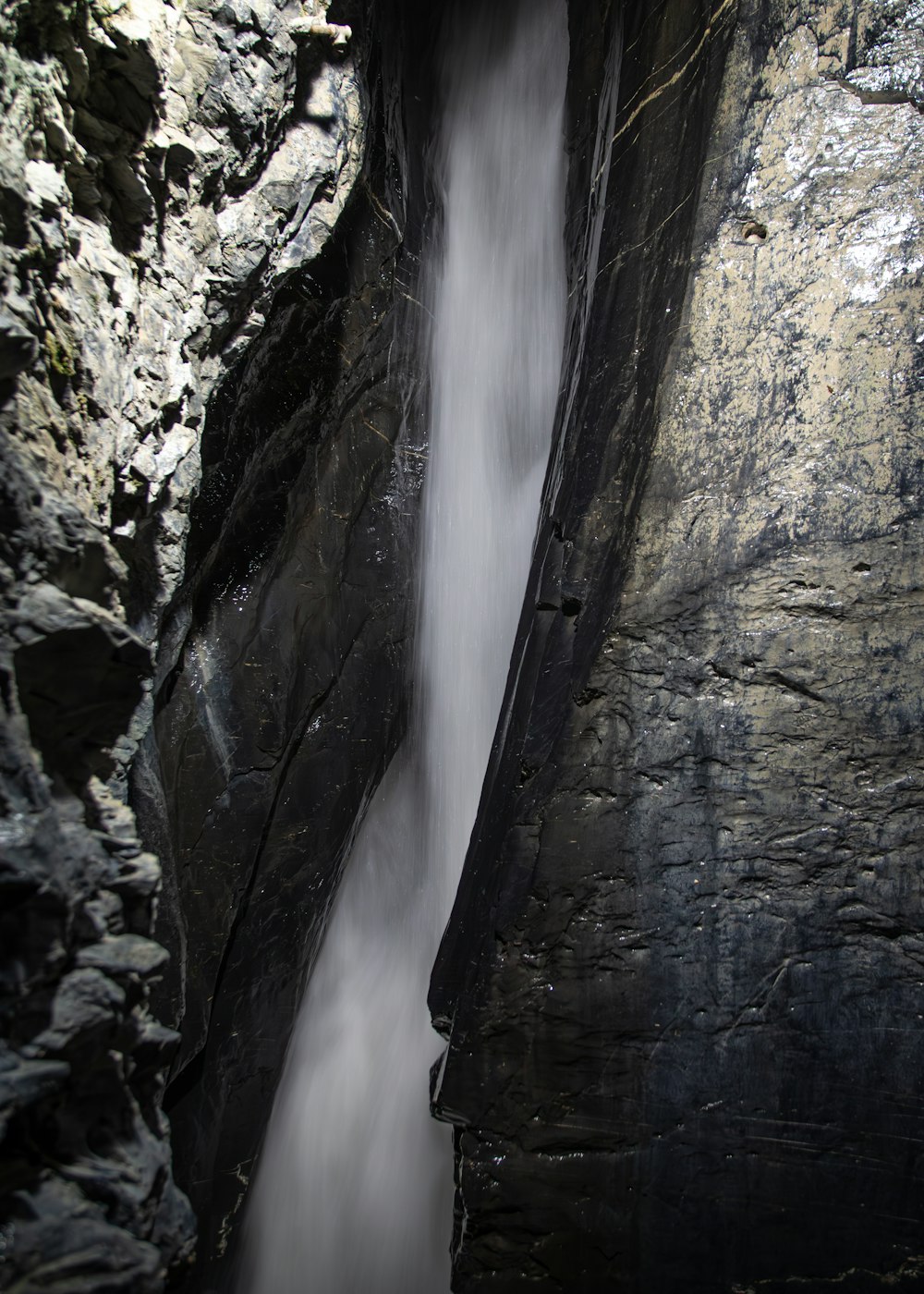 a waterfall is coming out of the side of a cliff