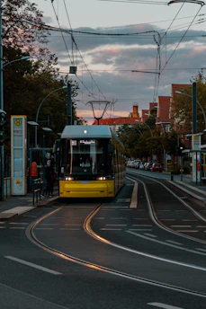 A sleek yellow and black public bus gliding through a city street at sunset, highlighting geltona linija's commitment to modern, reliable transport.