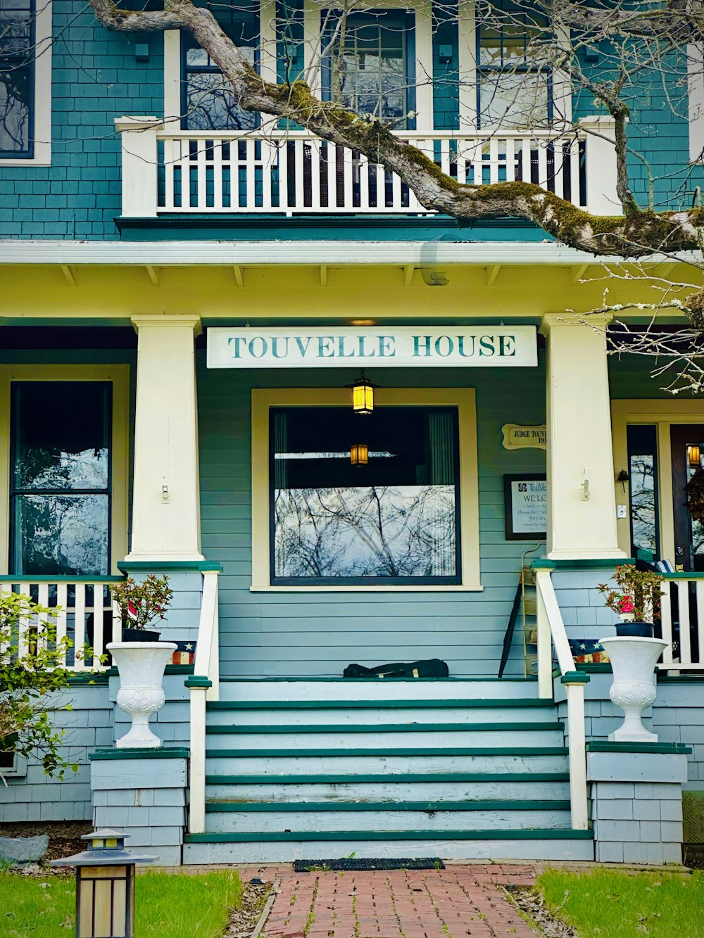 a blue and yellow house with a dog laying on the porch