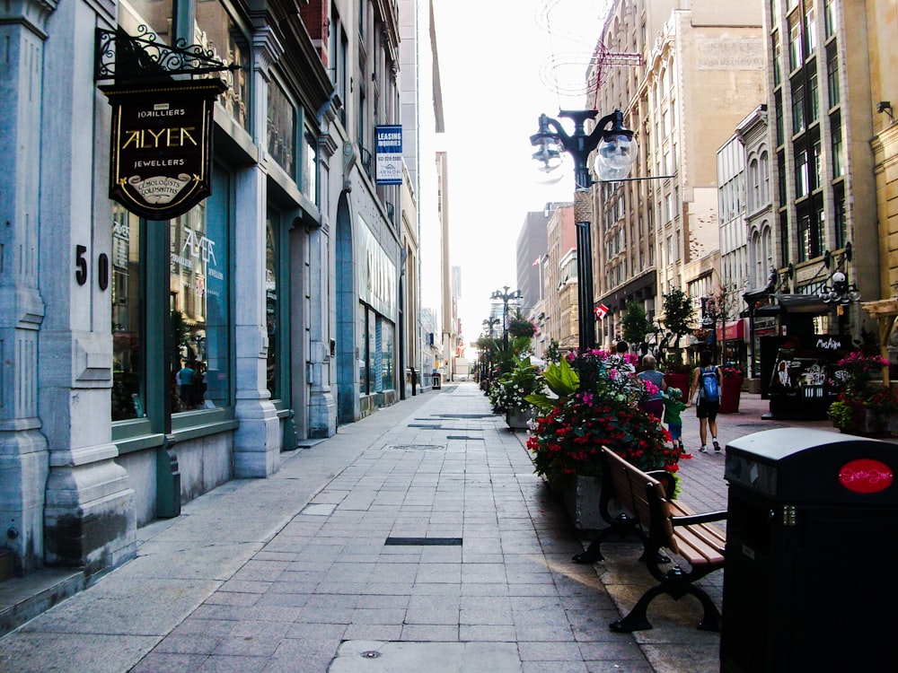 a city street lined with tall buildings and flowers