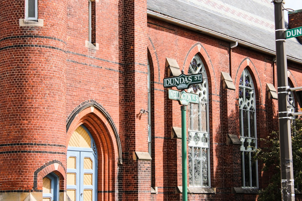 a red brick building with a street sign in front of it