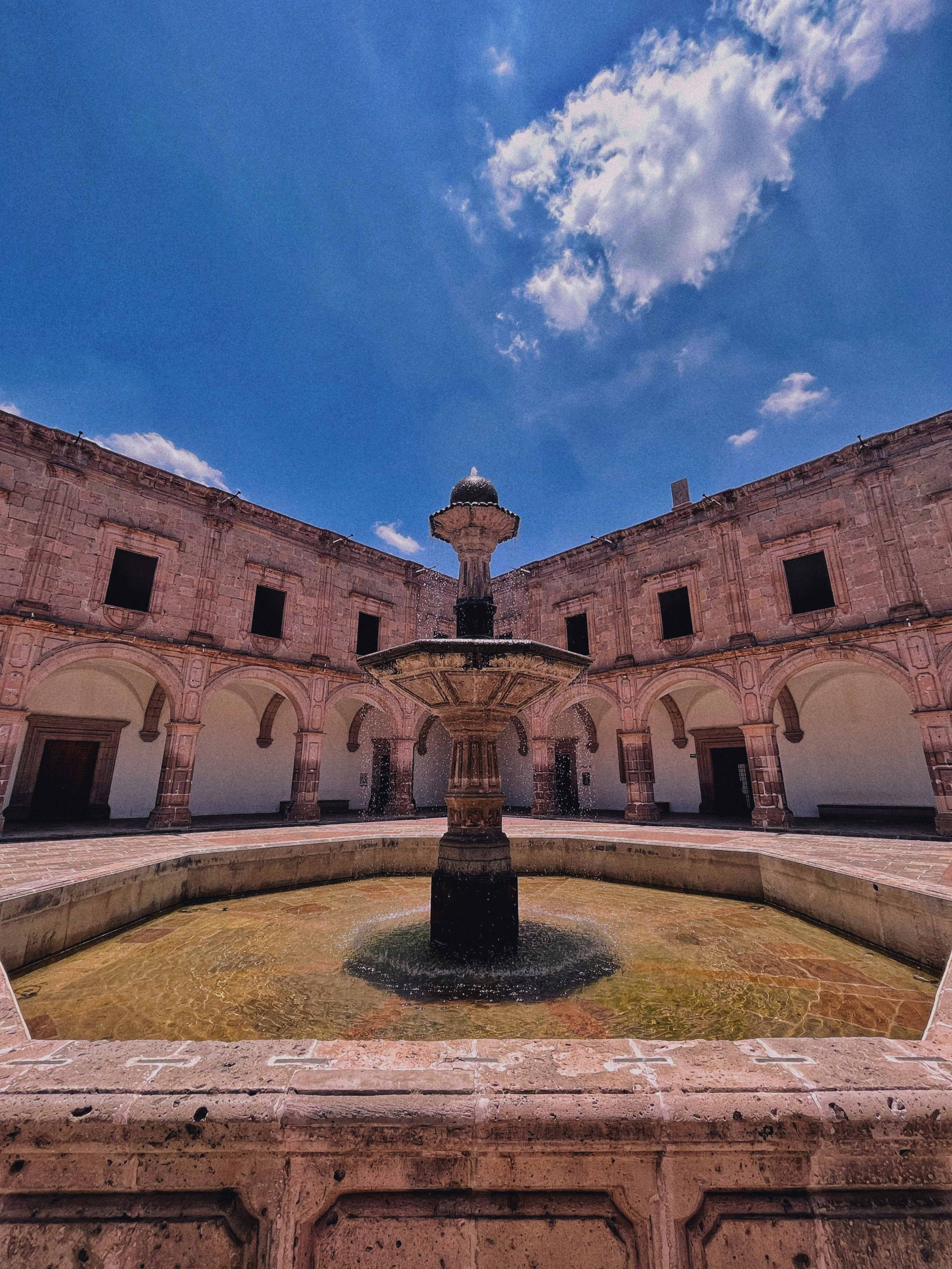 a courtyard with a fountain in the middle of it