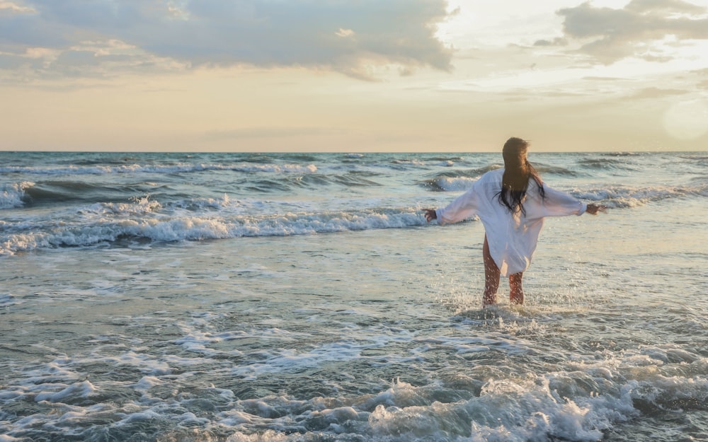 uma mulher em pé na água na praia