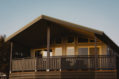 Front view of a newly built affordable home with a welcoming porch under a bright Texas sky.