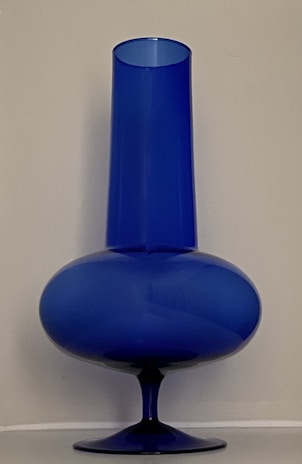 A glossy, cobalt blue vase with a minimalist silhouette and subtle curves.