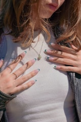 a close up of a woman with her hands on her chest
