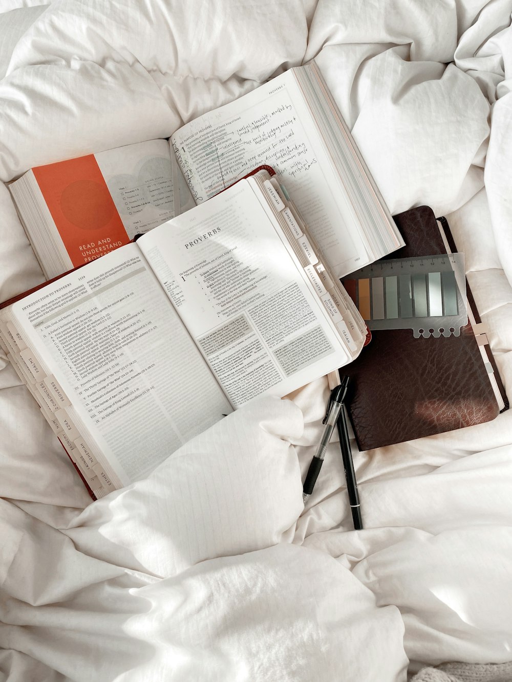 an open book sitting on top of a bed