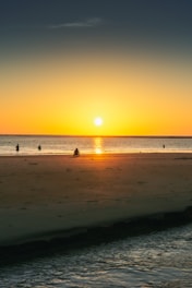 A serene beach in Sri Lanka with tourists enjoying a peaceful sunset.