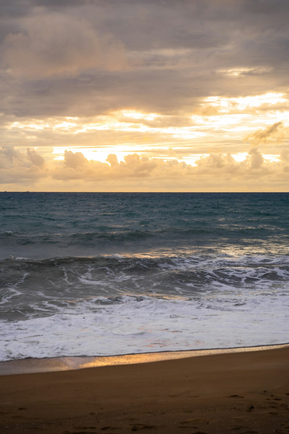 a person walking on the beach with a surfboard