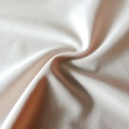 Close-up of soft, white 100% cotton fabric texture under natural light.