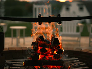 A warm, inviting campfire glowing softly in the evening with natural surroundings.