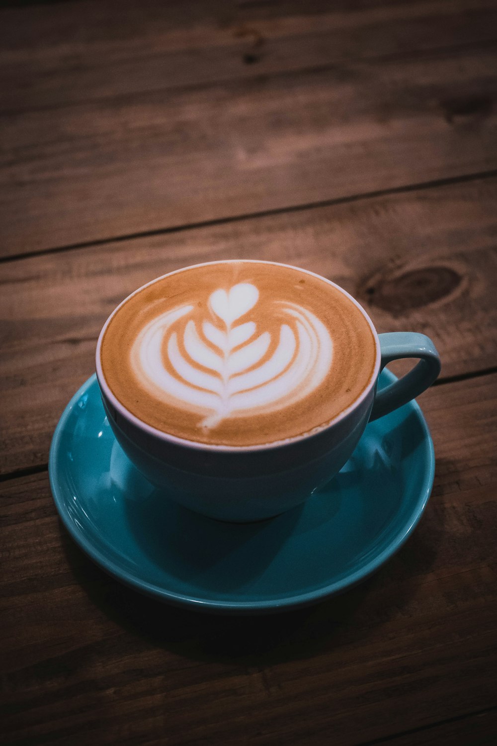 a cappuccino on a saucer on a wooden table