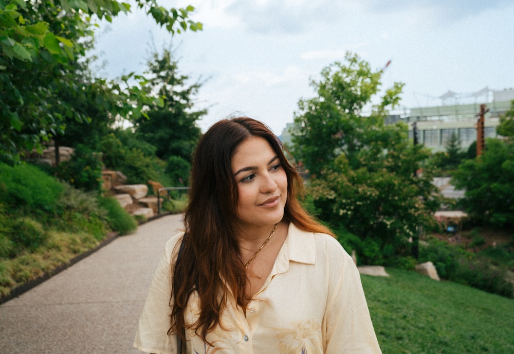 a woman standing on a path in a park