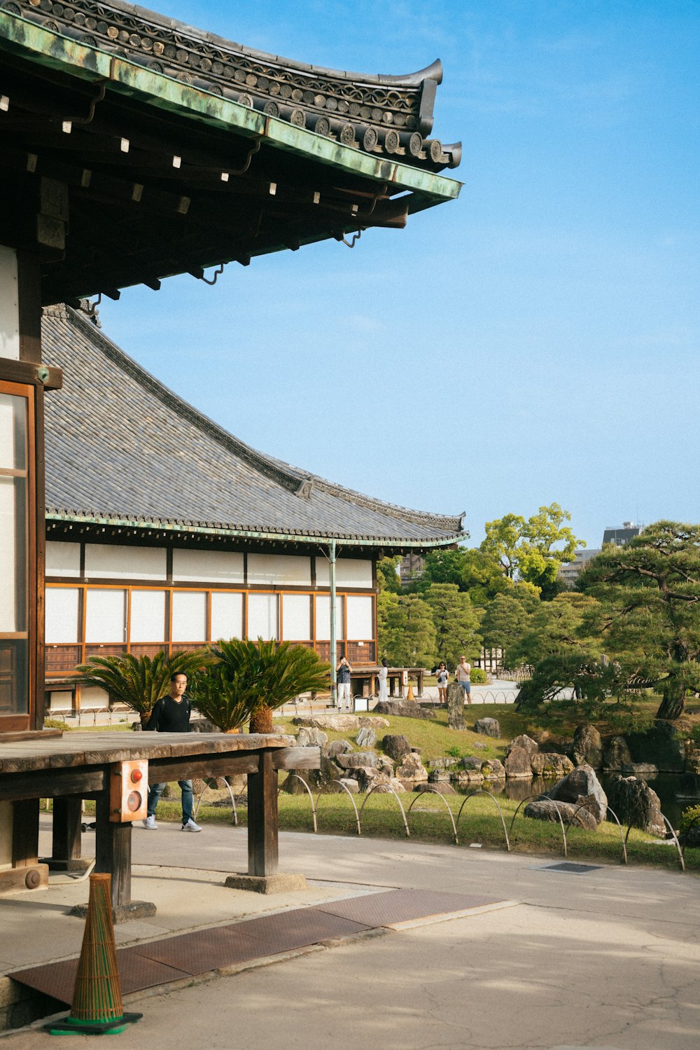 a large building with a wooden roof and a bench in front of it