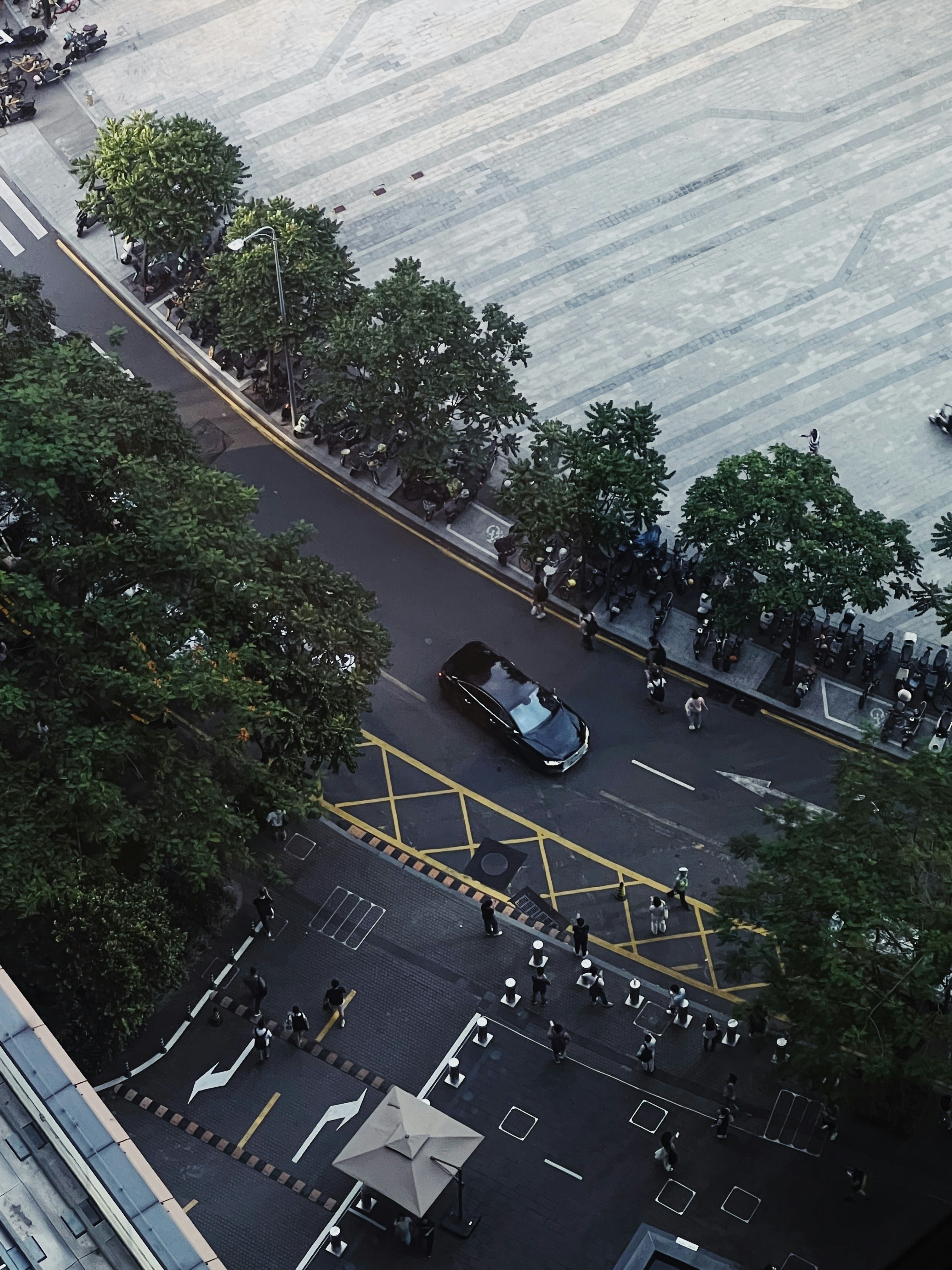 an aerial view of a city street with cars and people