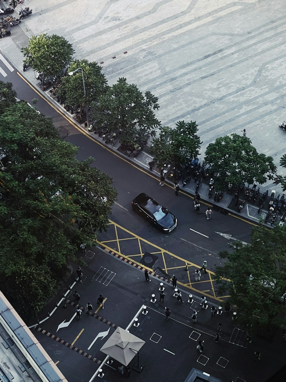 an aerial view of a city street with cars and people