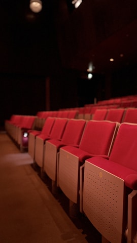 a row of empty red seats in a theater