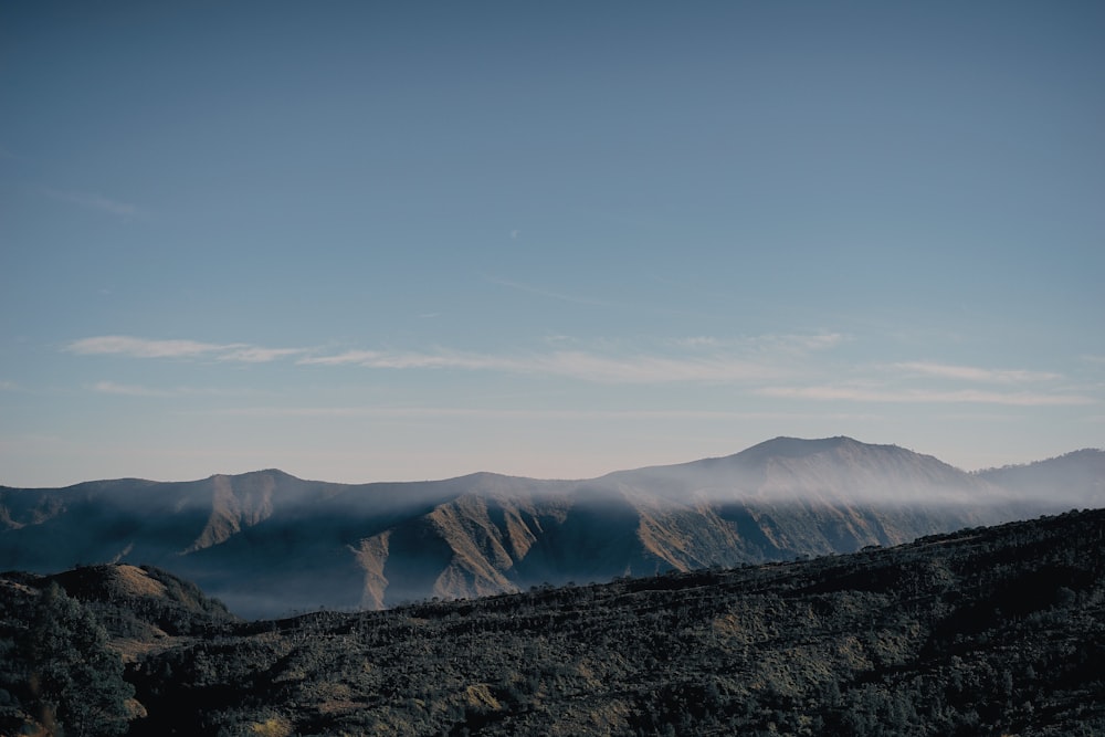 a view of a mountain range with low lying clouds