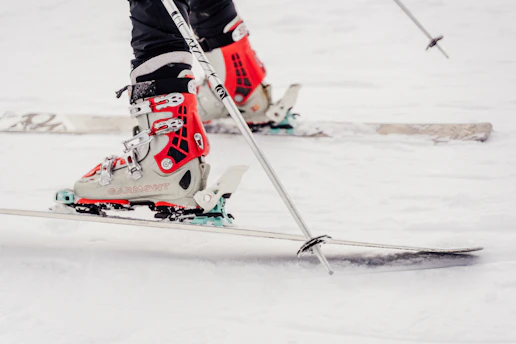 Close-up of ski boots being waxed on a snowy mountain background