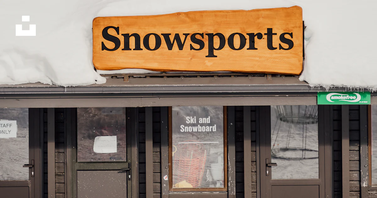 A snow sports store with a sign on the roof photo – Free Shelter Image ...