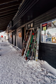 a row of snow skis sitting next to a building
