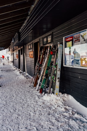 a row of snow skis sitting next to a building