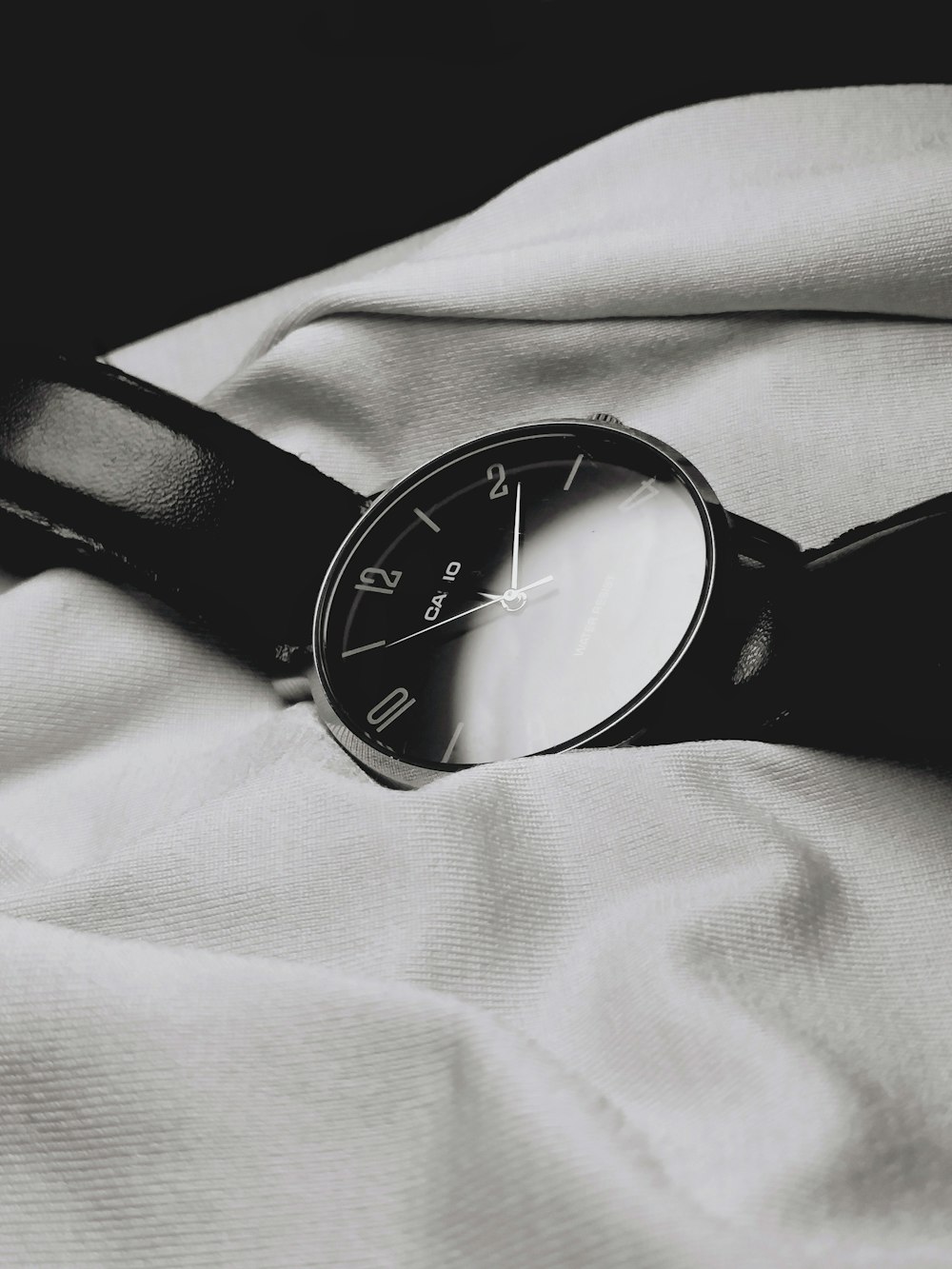 a watch sitting on top of a white sheet