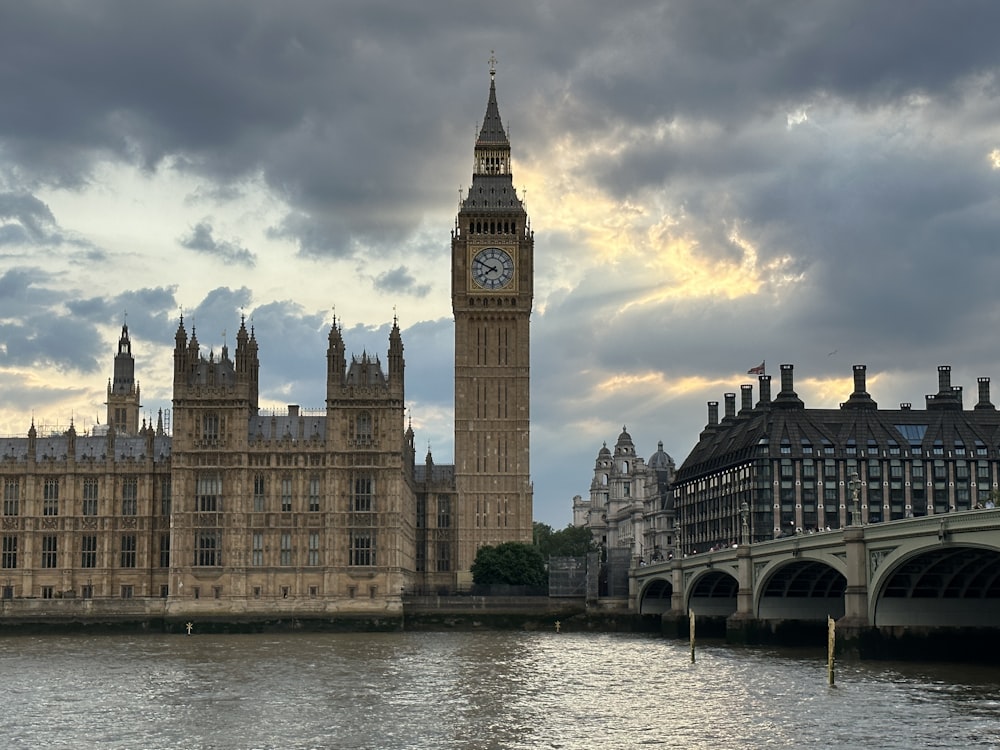 a large clock tower towering over a city next to a river