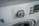 A close-up view of a washing machine control panel with various washing options such as Speed Wash, Cotton, Synthetic, and others. The dial knob is prominently positioned, slightly tilted to the left. Adjacent buttons display functions like Delay and Temperature.
