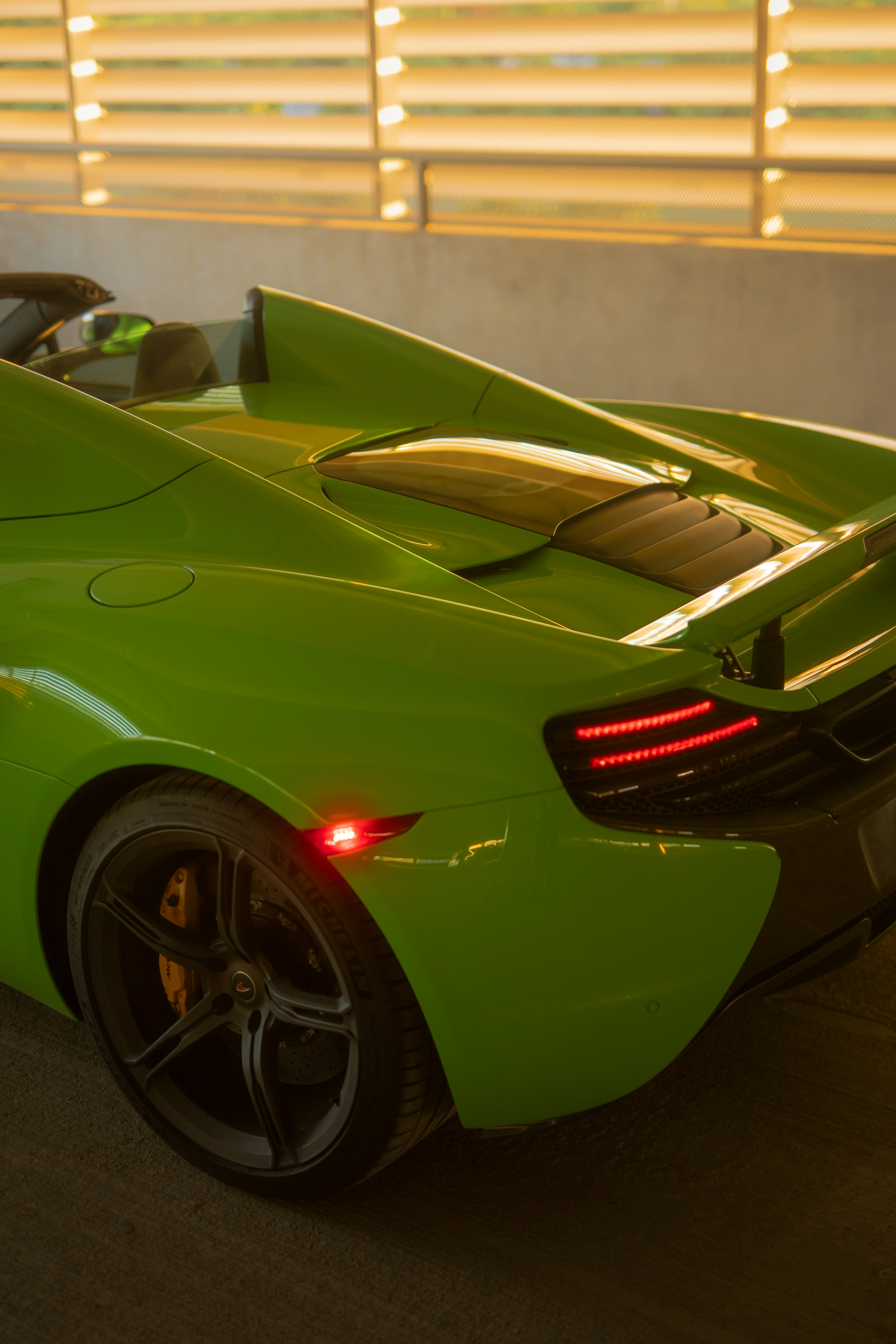 a green sports car parked in front of a building