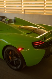 A sleek black car with a fresh lime green respray gleaming under the sunlight.