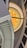The image features a modern architectural interior with a prominent staircase curving upward. The ceiling displays a large circular design with a geometric pattern resembling a star or sunburst. The use of yellow and orange hues adds a vibrant touch to the space.
