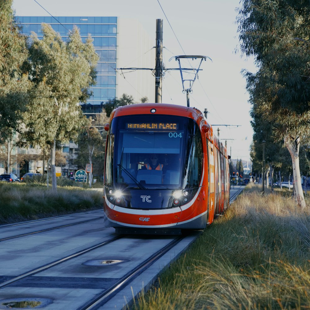 a red and white train traveling down train tracks