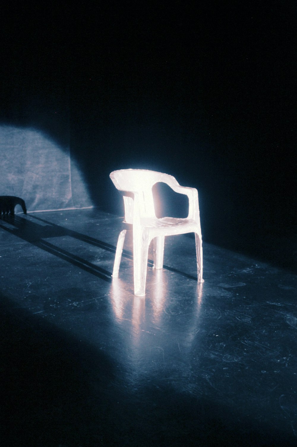 a white chair sitting in the middle of a dark room