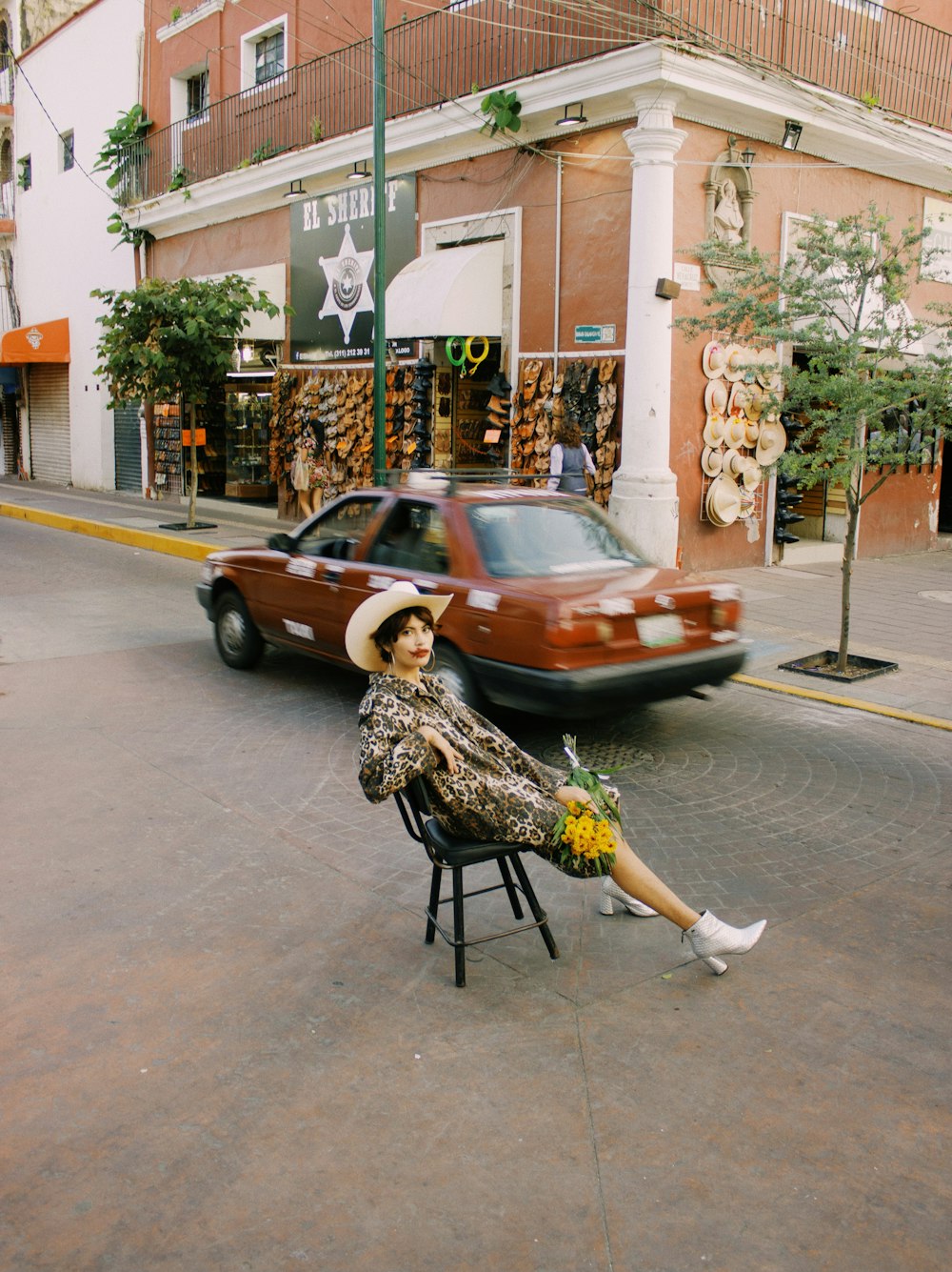 a woman sitting on a chair in the middle of the street