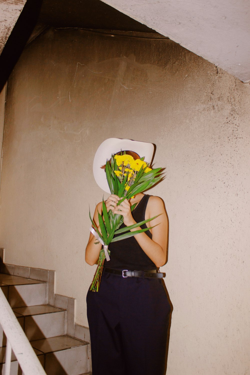 Une femme tenant un bouquet de fleurs devant son visage