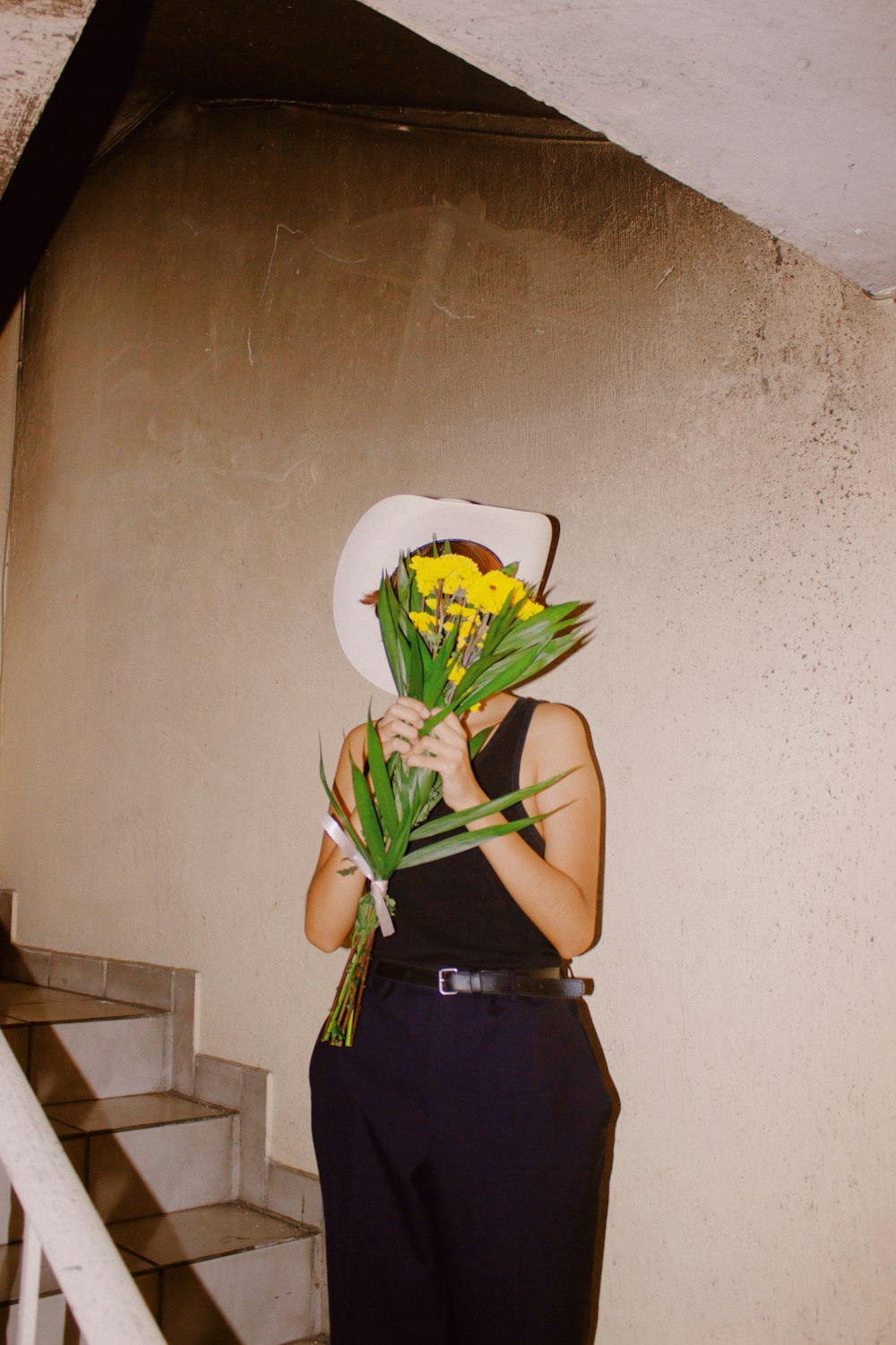 a woman holding a bunch of flowers in front of her face