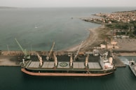 A panoramic view of a large cargo ship docked at an international port.