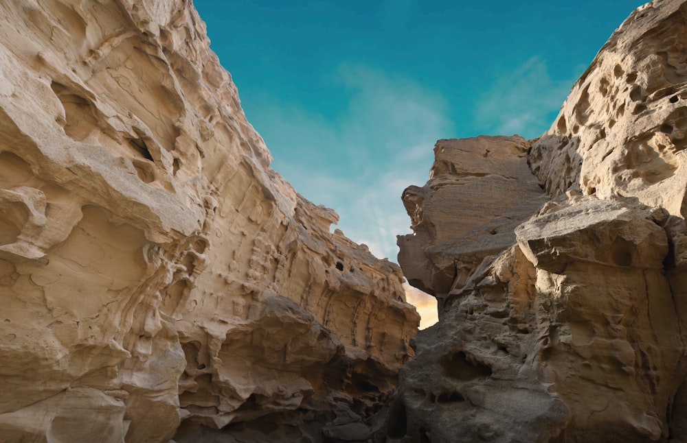 a narrow slot in a rock formation with a blue sky in the background