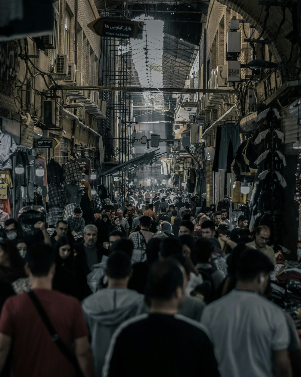 a crowd of people walking down a street next to tall buildings