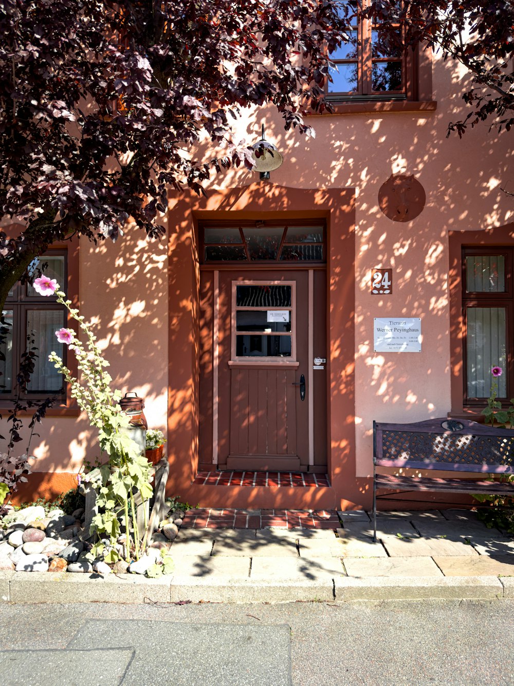 a pink building with a wooden bench in front of it