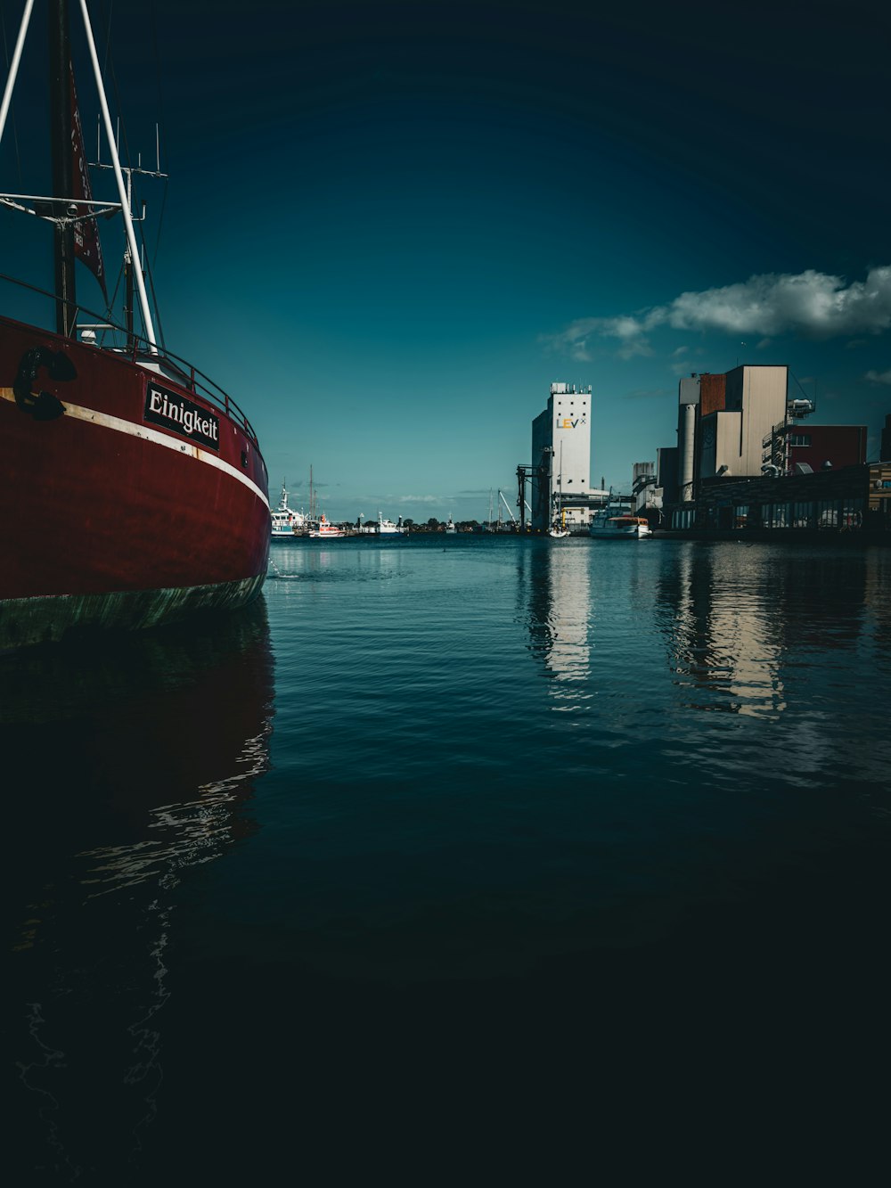 a red boat floating on top of a body of water