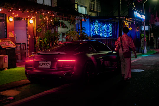 A polished black 2019 Audi A4 parked on a city street at dusk with soft red taillights glowing.