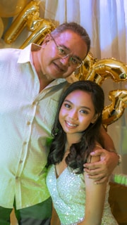 A joyful couple smiling as they celebrate their event surrounded by tasteful decorations.