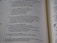 A close-up view of an open book displaying text in a poetic layout, with lines of varying lengths and indentation. The font is clear, and the page appears to be from a religious or scholarly text, possibly a Bible, due to the structured verse format and references to theological themes.