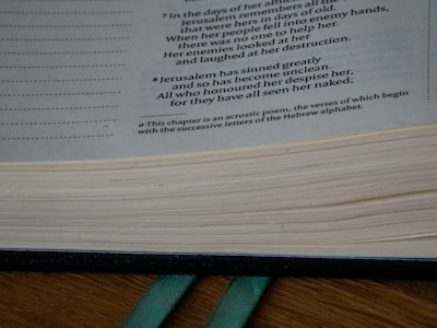 Close-up of hands flipping through the pages of 'El Convenio' with a green and gold bookmark.