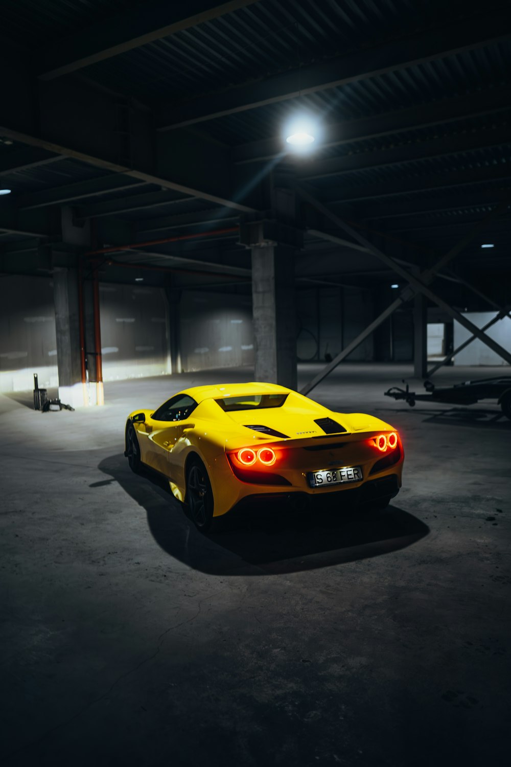 a yellow sports car parked in a parking garage