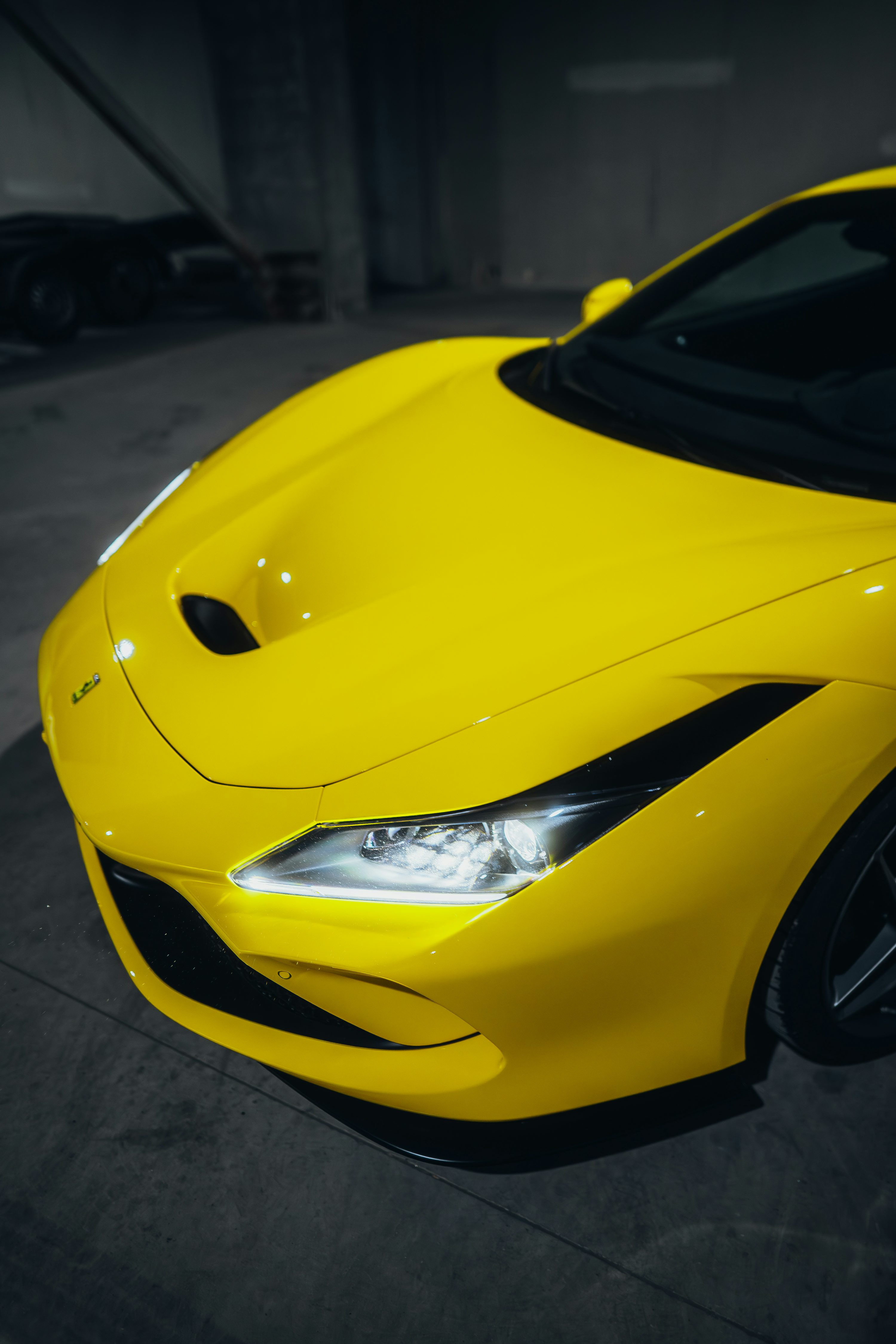a yellow sports car parked in a parking garage